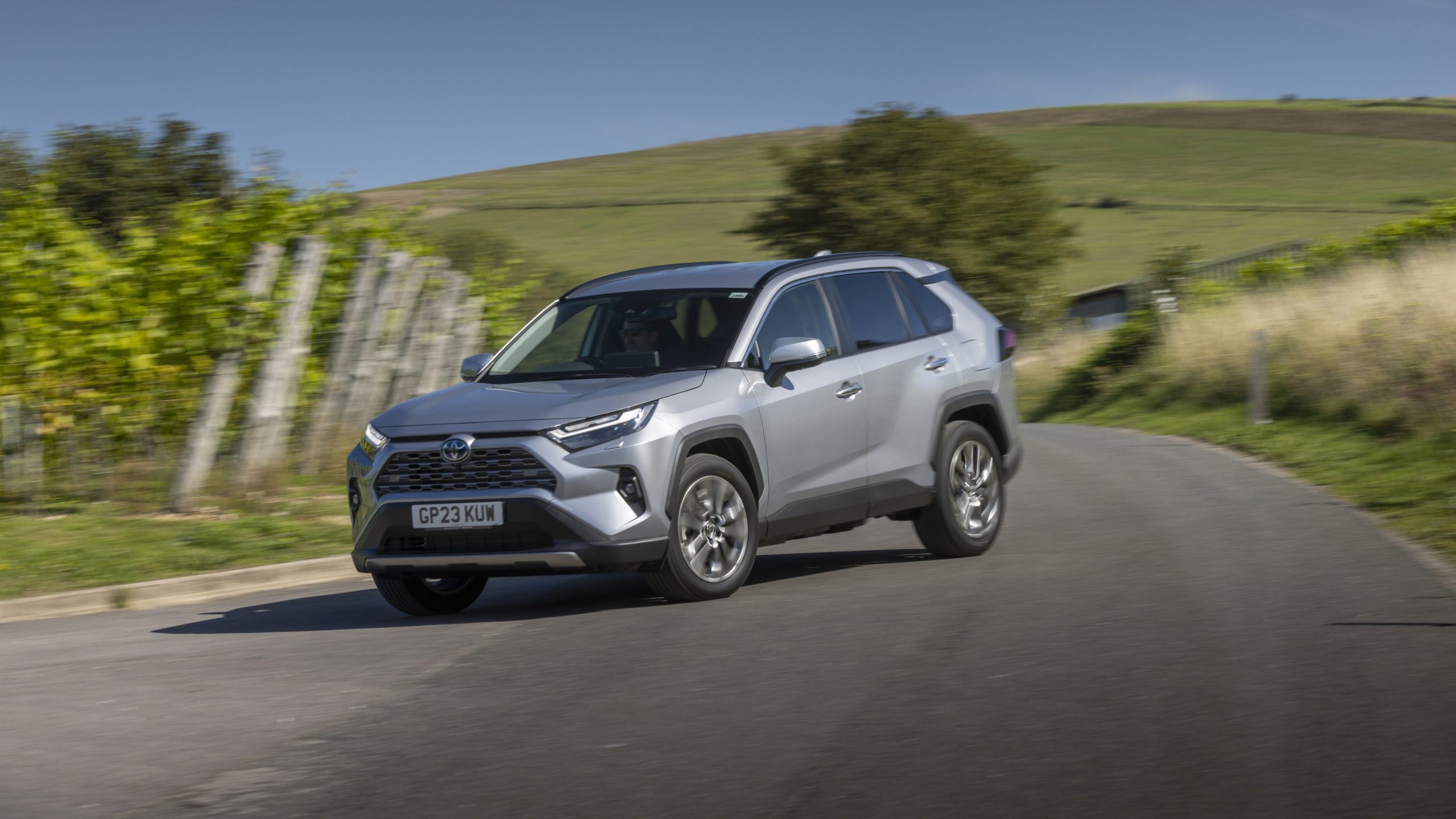 Silver Toyota RAV4 driving countryside front