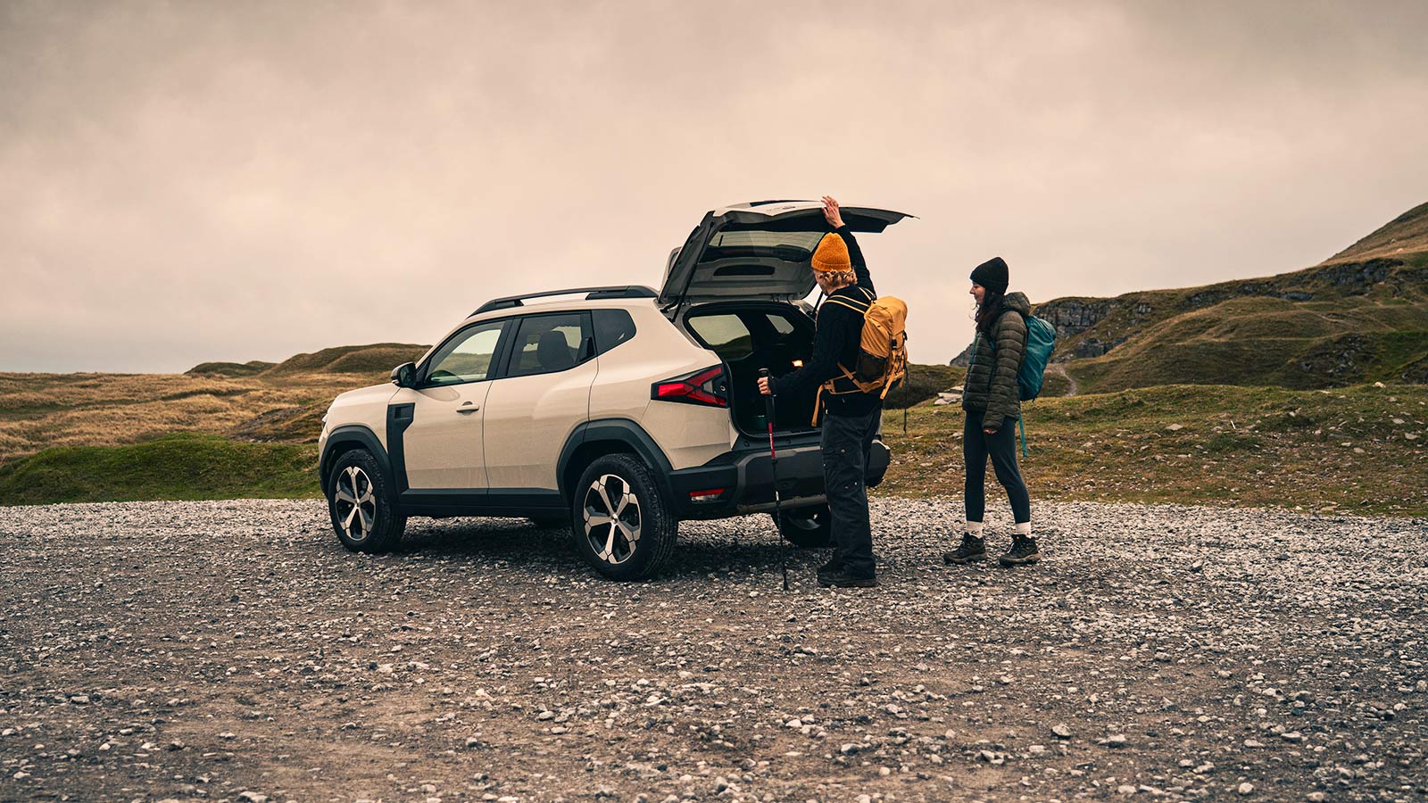 Dacia Duster in beige, boot open, static rear three quarter