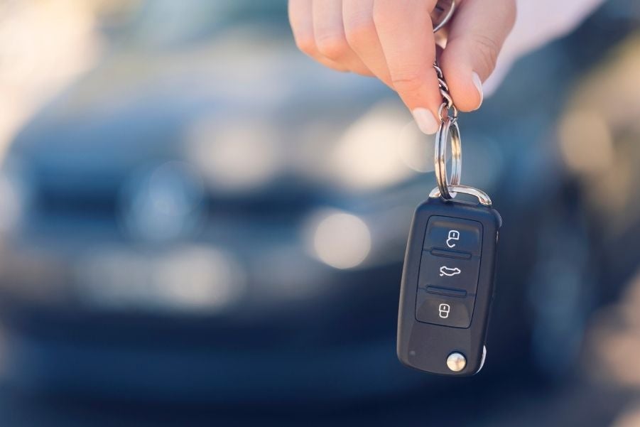 A set of car keys in front of a blurred out car