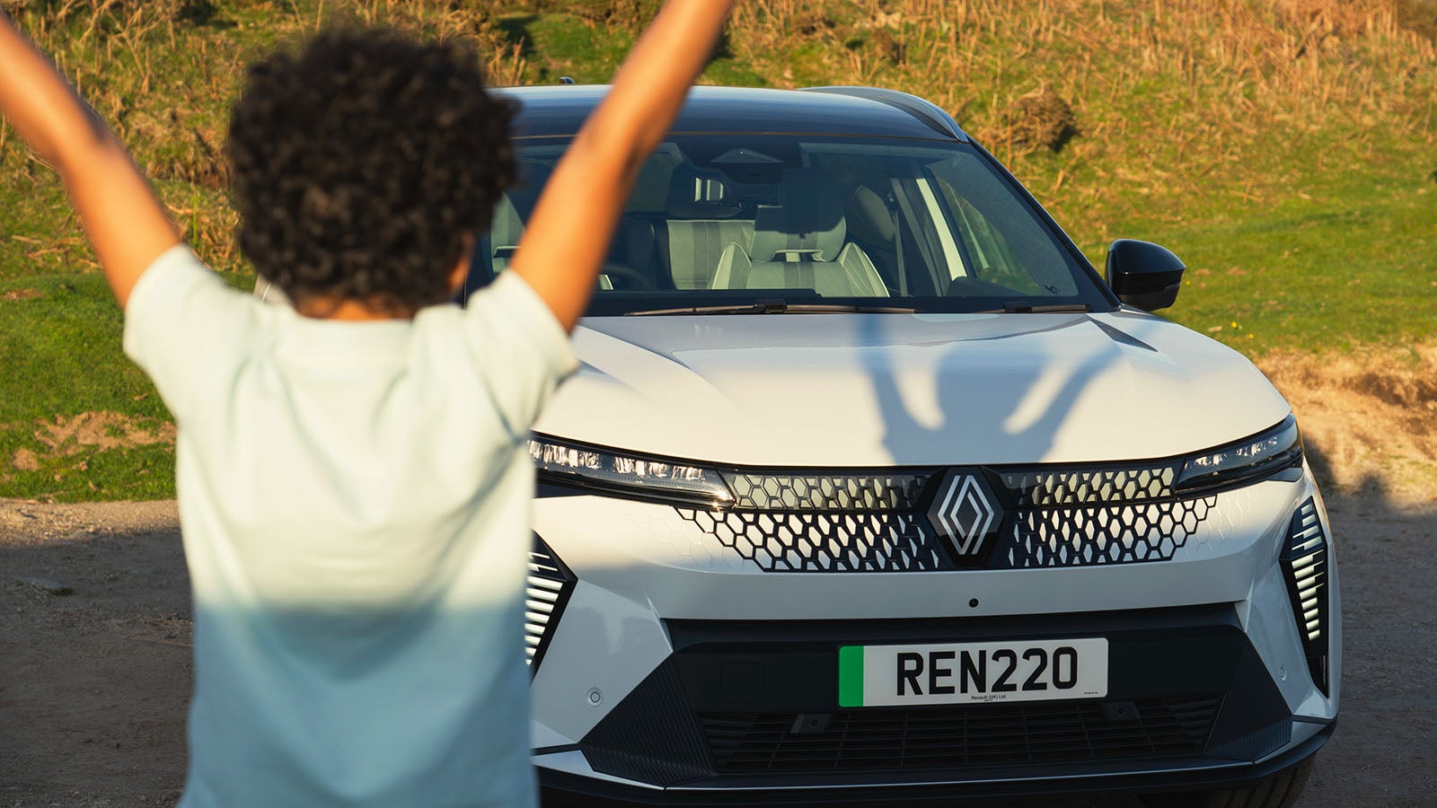 Renault Scenic E-Tech in white, front on, child in foreground