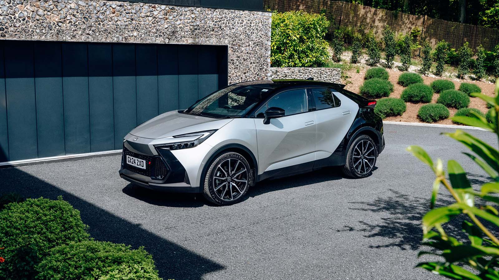 Toyota C-HR in silver, static outside a fancy house